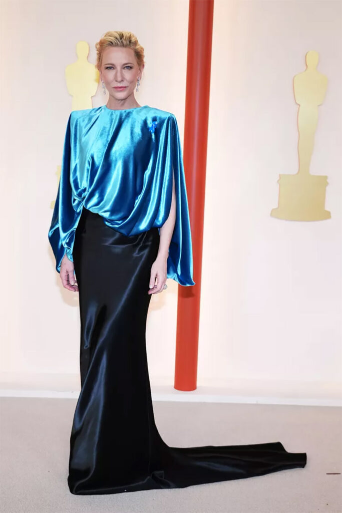 Cate Blanchett ในเสื้อตัวบนสีเขียวทีลจับคู่กับกระโปรงสอบลากหางยาวสีเนวีบลู งานคัสตอมที่ไม่เคยปรากฏในคอลเล็กชั่นใดๆมาก่อนของ Louis Vuitton