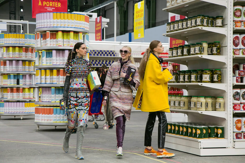 โชว์ฤดูใบไม้ร่วง 2014 คาร์ลกลับทำในธีมซูเปอร์มาร์เก็ตที่นางแบบใส่เสื้อฮู้ดกีฬา กางเกงวอร์มและสนีกเกอร์ออกมาช้อปปิ้งของชำใน Chanel Supermarket